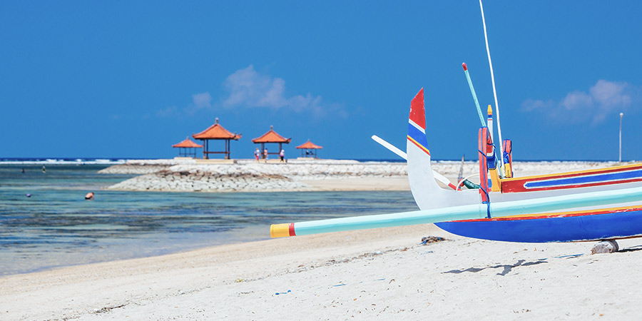 Beach scene and traditional Balinese boat on a Sanur beach in Bali, Indonesia